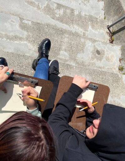 two artist sitting on stairs sketching