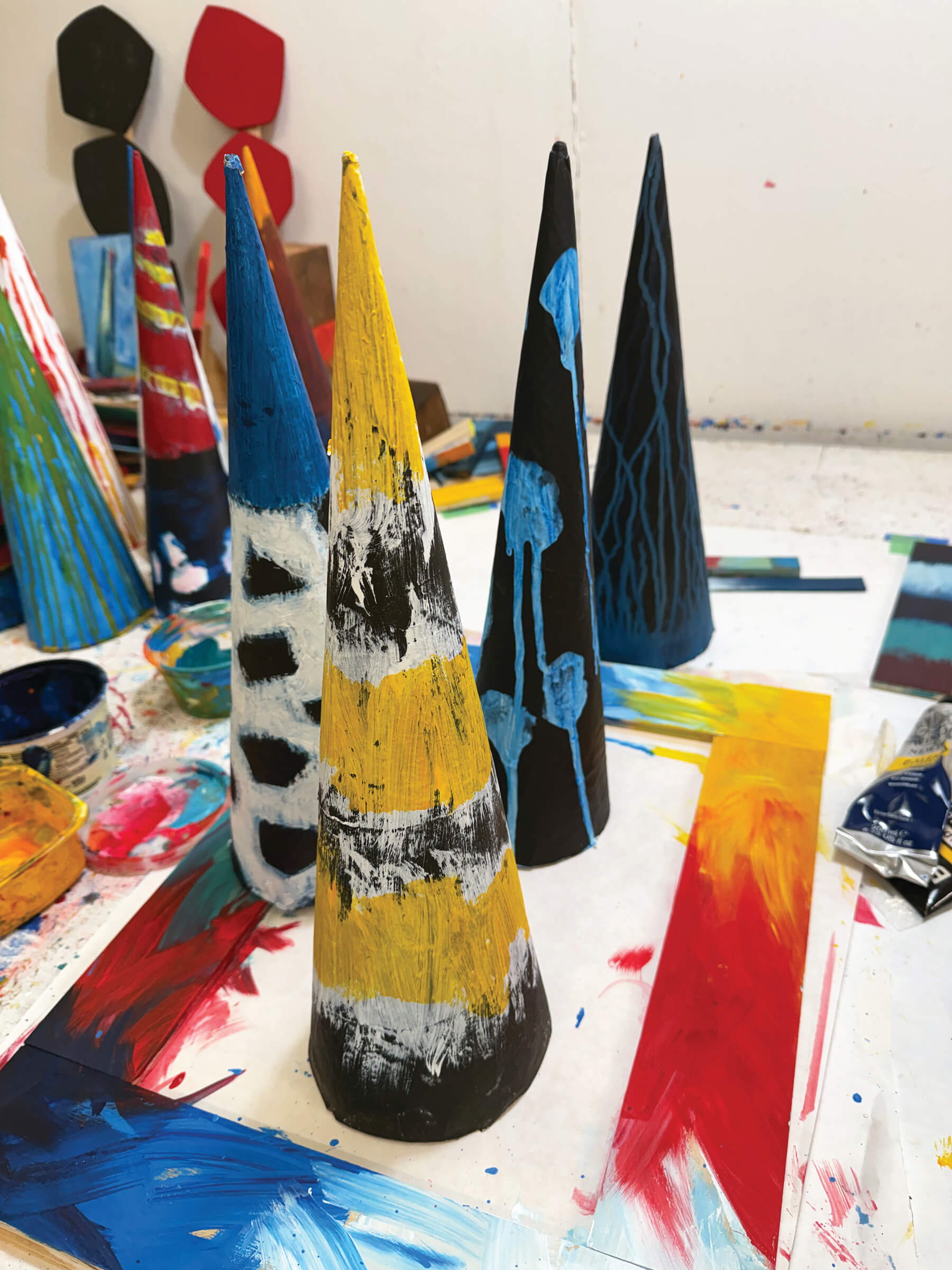 multicolored painted cone shapes displayed on an artist's work table